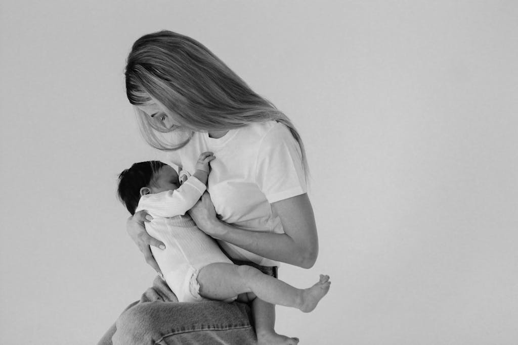 A touching black and white image of a mother tenderly breastfeeding her baby. Baby Feeding Essentials