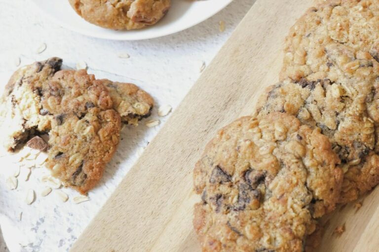 Delicious homemade oatmeal lactation cookies served with a glass of fresh milk on a wooden board.