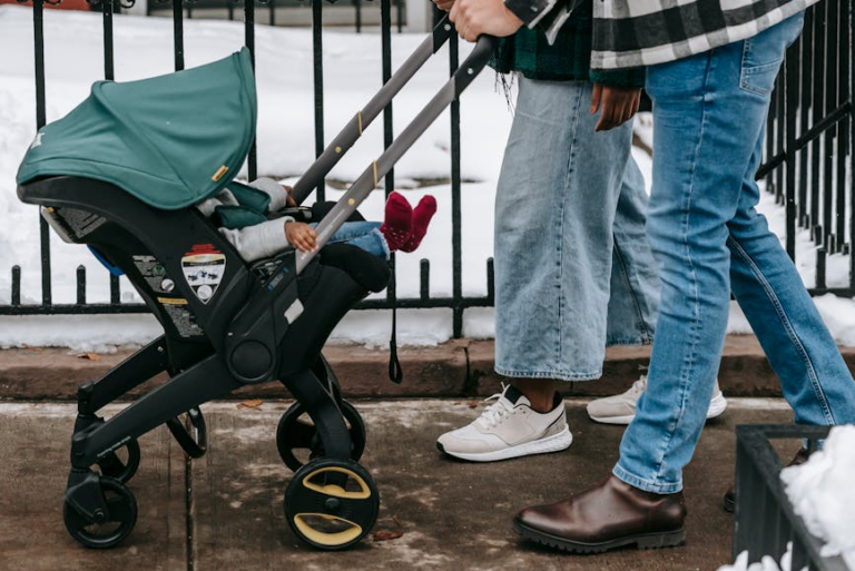 couple walking baby in doona stroller in winter