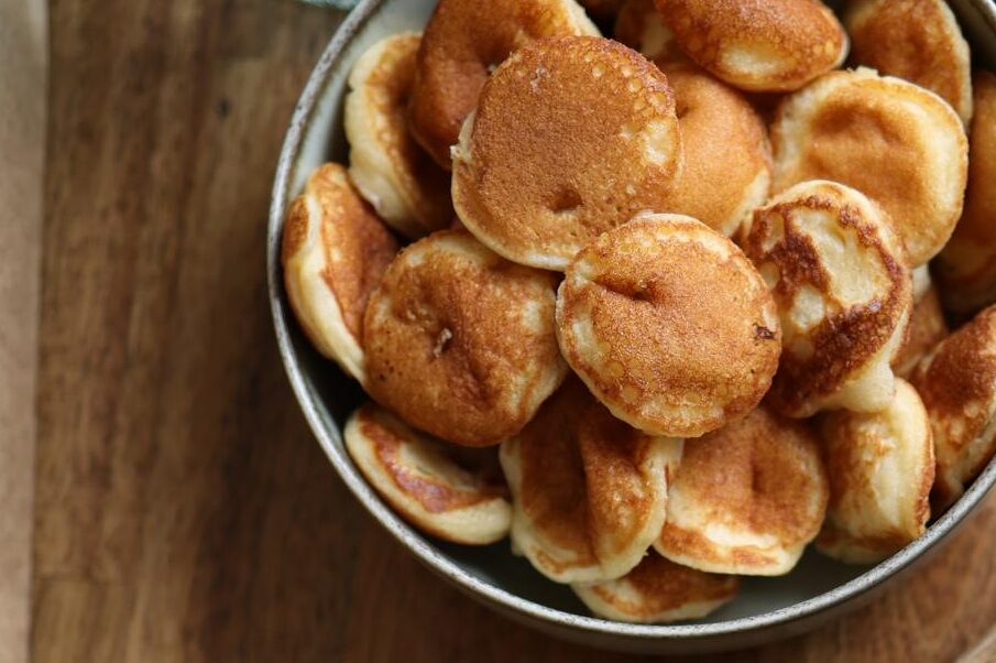 A flat lay showcasing baby pancakes on a wooden table.