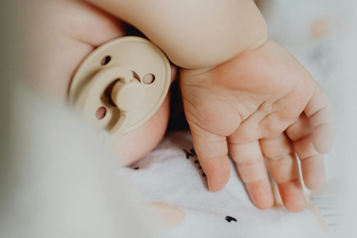 ditch the pacifier: A serene close-up of a sleeping baby with a pacifier, showcasing tenderness and tranquility.
