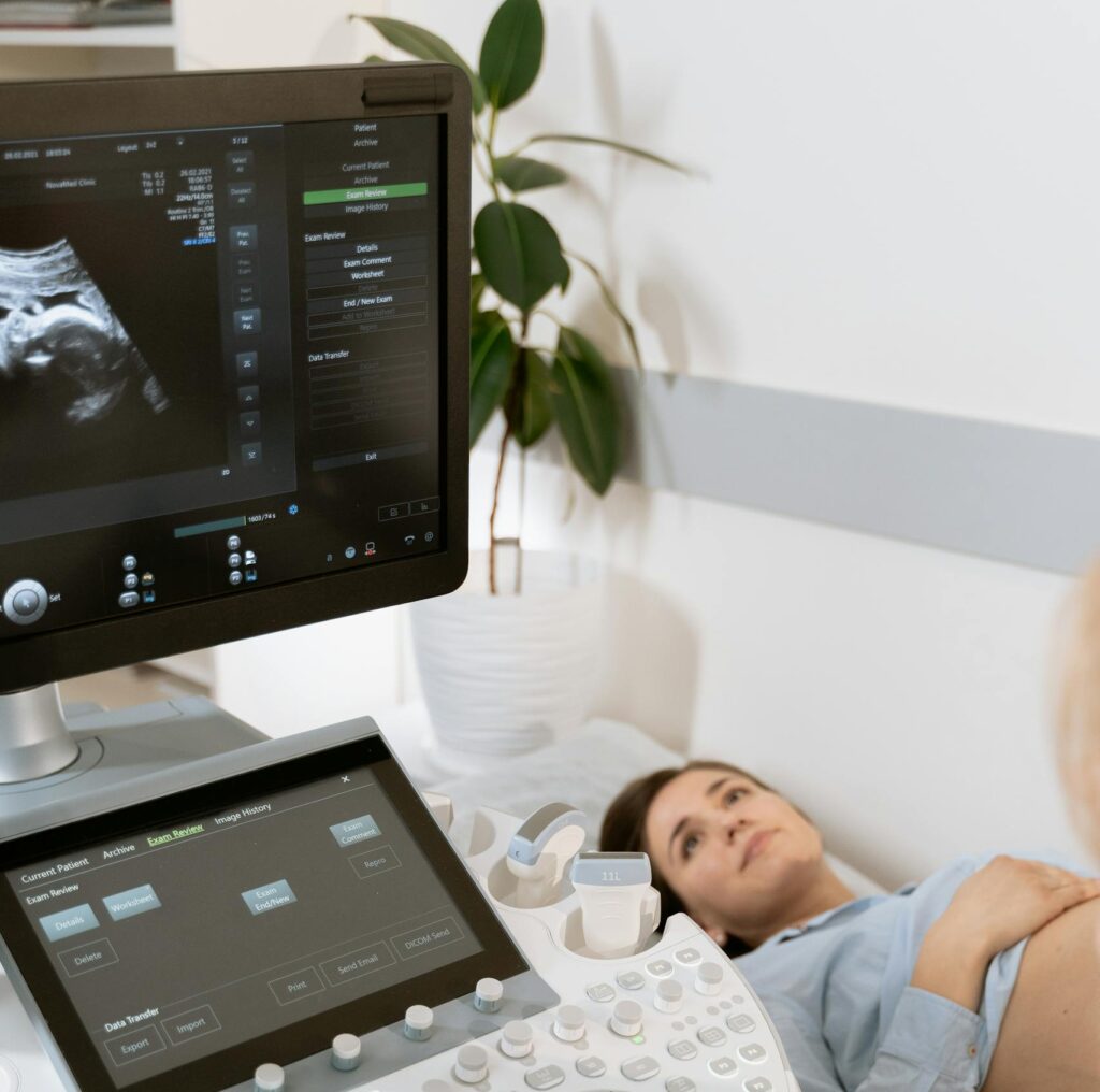 Pregnant woman undergoes ultrasound scan by medical professional in hospital room. Gender Disappointment